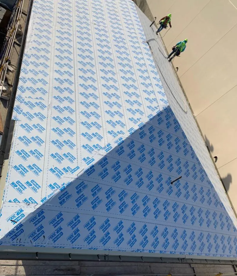 Professional roofers installing underlayment on a metal roof in North Tonawanda